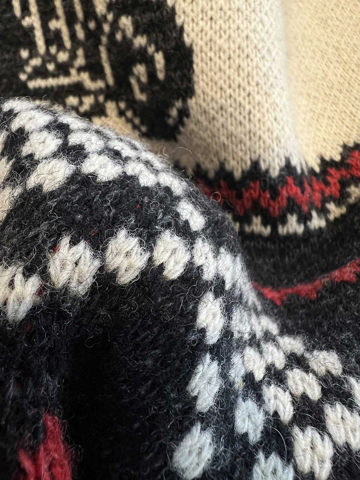 製品画像: ヴィンテージバイカージャカードウールカーディガン全体イメージ画像。バイクモチーフのジャカード織りと赤・黒・白のクラシックな配色が特徴で、自由とヴィンテージ感を象徴するデザイン。秋冬の重ね着スタイルに最適。
詳細画像: ジャカード織りで描かれたバイクモチーフと、クラシックなダブルジップディテールをクローズアップした画像。暖かいウール素材と細部へのこだわりが際立つ。