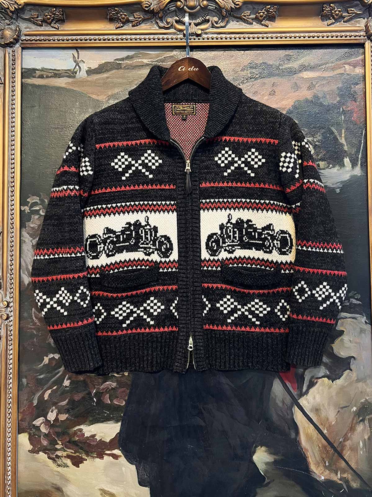 製品画像: ヴィンテージバイカージャカードウールカーディガン全体イメージ画像。バイクモチーフのジャカード織りと赤・黒・白のクラシックな配色が特徴で、自由とヴィンテージ感を象徴するデザイン。秋冬の重ね着スタイルに最適。
詳細画像: ジャカード織りで描かれたバイクモチーフと、クラシックなダブルジップディテールをクローズアップした画像。暖かいウール素材と細部へのこだわりが際立つ。