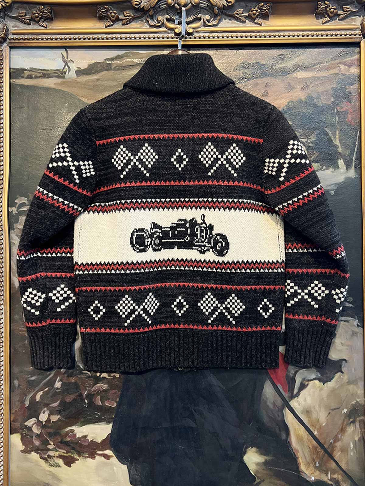 製品画像: ヴィンテージバイカージャカードウールカーディガン全体イメージ画像。バイクモチーフのジャカード織りと赤・黒・白のクラシックな配色が特徴で、自由とヴィンテージ感を象徴するデザイン。秋冬の重ね着スタイルに最適。
詳細画像: ジャカード織りで描かれたバイクモチーフと、クラシックなダブルジップディテールをクローズアップした画像。暖かいウール素材と細部へのこだわりが際立つ。