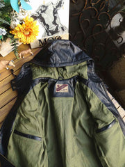 製品画像: 9ポケットフィールドフード付きフルグレインレザージャケット全体イメージ画像。黒いシボ加工レザーとヴィンテージ感漂うオイル仕上げのスエードディテールが特徴で、アウトドアやバイクライドにも適した多機能デザイン。
詳細画像: YKKアンティークブロンズジッパーとオイルドスエードレザーの補強ディテールをクローズアップした画像。耐久性とクラシックな風合いが際立つ仕上がり。