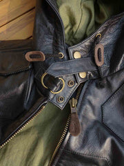 製品画像: 9ポケットフィールドフード付きフルグレインレザージャケット全体イメージ画像。黒いシボ加工レザーとヴィンテージ感漂うオイル仕上げのスエードディテールが特徴で、アウトドアやバイクライドにも適した多機能デザイン。
詳細画像: YKKアンティークブロンズジッパーとオイルドスエードレザーの補強ディテールをクローズアップした画像。耐久性とクラシックな風合いが際立つ仕上がり。