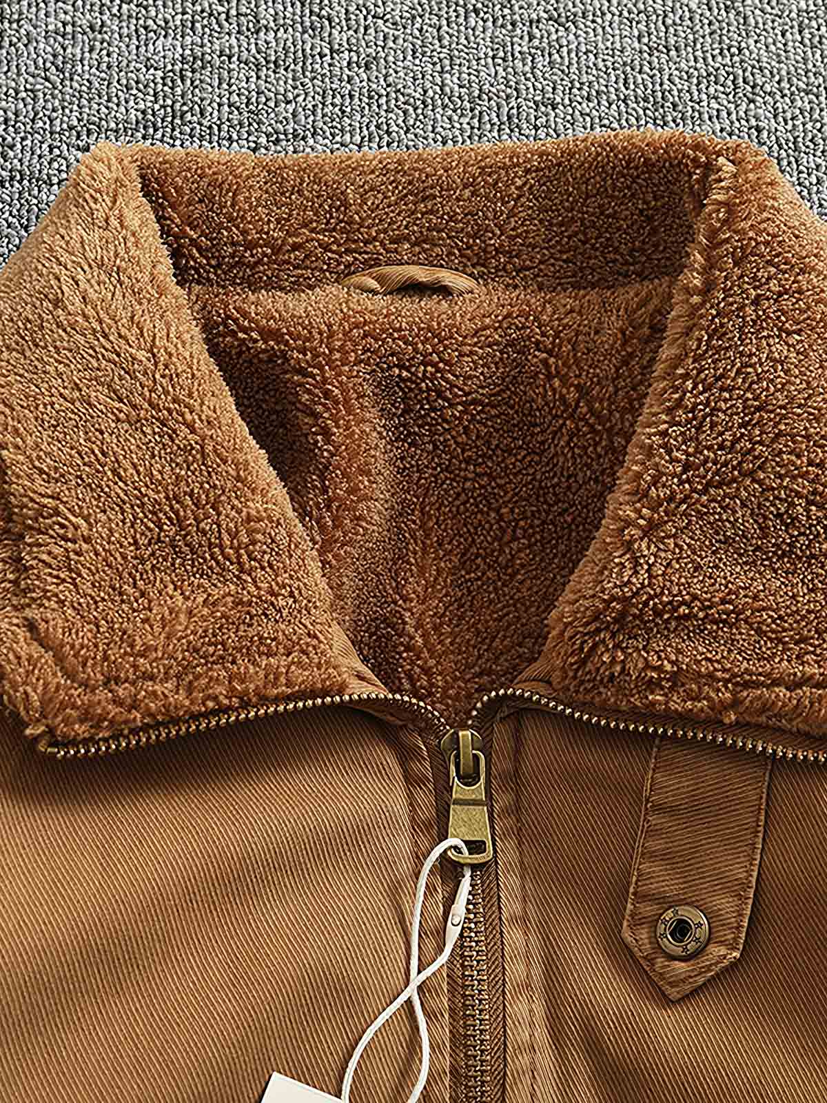 製品画像:
"水洗い加工を施したシープスキンライニング付きフライトジャケットの全体図。クラシックなアメカジスタイル、シープスキンカラーとツイル織りコットンの組み合わせでヴィンテージ感を引き立てたデザイン"
詳細画像:
"シープスキン風ライニングとリブ仕様の裾ディテールをクローズアップした画像。裏地の柔らかさと保温性が際立ち、防風性を兼ね備えたデザインが強調される"