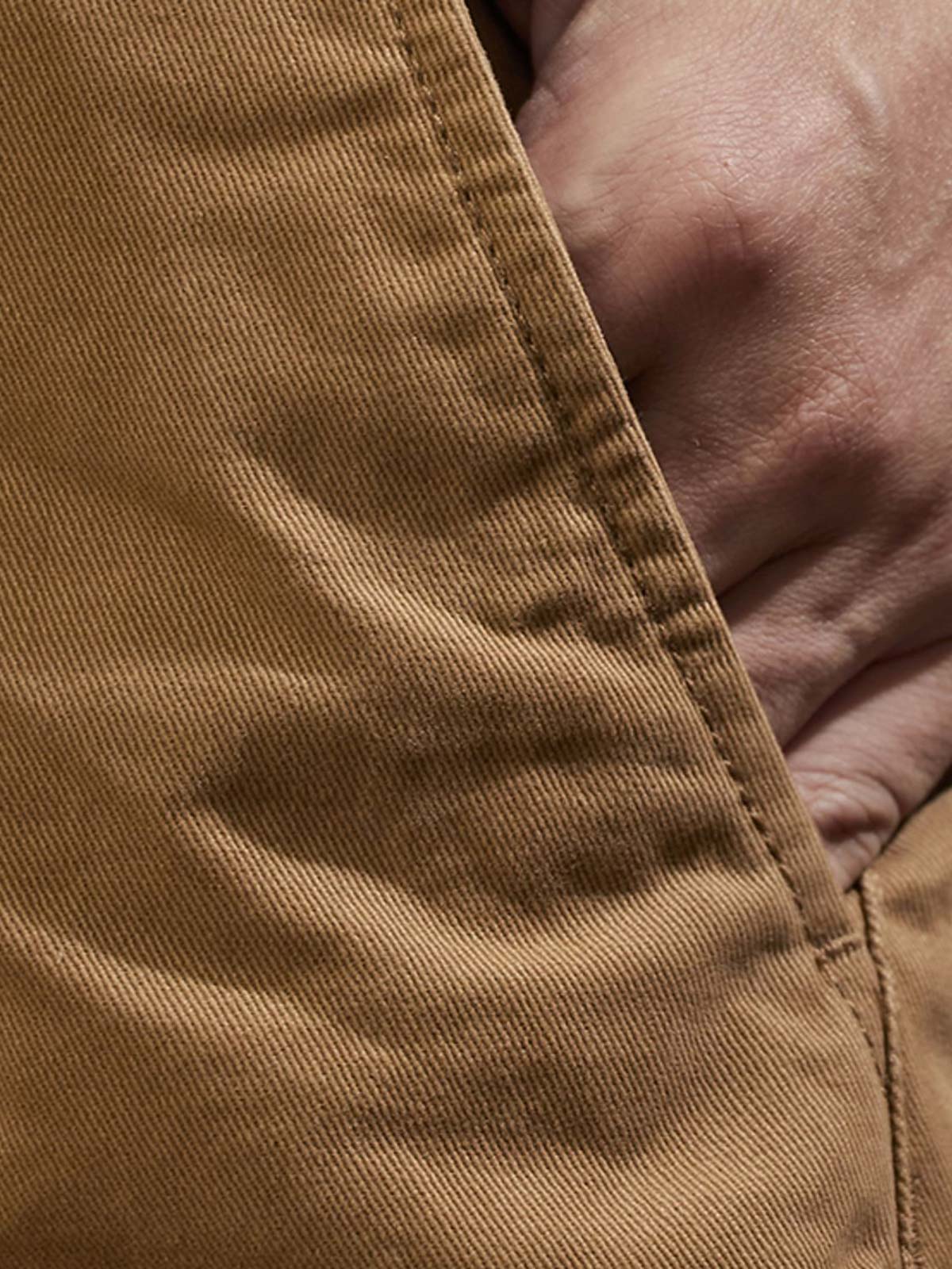 製品画像:紫タグが付いたワーク テーパードパンツの全体像。高品質な純銅YKKジッパーや金属ボタン、そしてしっかりとしたテーパードシルエットが際立ち、スタイリッシュで実用的なデザインが特徴のパンツを全体的に見せる展示画像。
詳細画像:紫タグが強調されたバックルベルトと隠しワークポケットのディテールクローズアップ。バックルベルト部分の調節機能と隠しポケットのディテールが、実用性とデザイン性を兼ね備えた特徴を詳しく見せる画像。