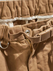 製品画像:紫タグが付いたワーク テーパードパンツの全体像。高品質な純銅YKKジッパーや金属ボタン、そしてしっかりとしたテーパードシルエットが際立ち、スタイリッシュで実用的なデザインが特徴のパンツを全体的に見せる展示画像。
詳細画像:紫タグが強調されたバックルベルトと隠しワークポケットのディテールクローズアップ。バックルベルト部分の調節機能と隠しポケットのディテールが、実用性とデザイン性を兼ね備えた特徴を詳しく見せる画像。