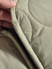 製品画像:
軽量で高密度撥水素材を使用したアウトドアスタイルのキルティングインサレーションベスト、波模様のキルティングデザインと大容量ワークポケット付き
詳細画像:
波模様のキルティングデザイン、細部にこだわった高密度撥水素材、内側の起毛素材とバックル開きディテールのクローズアップ