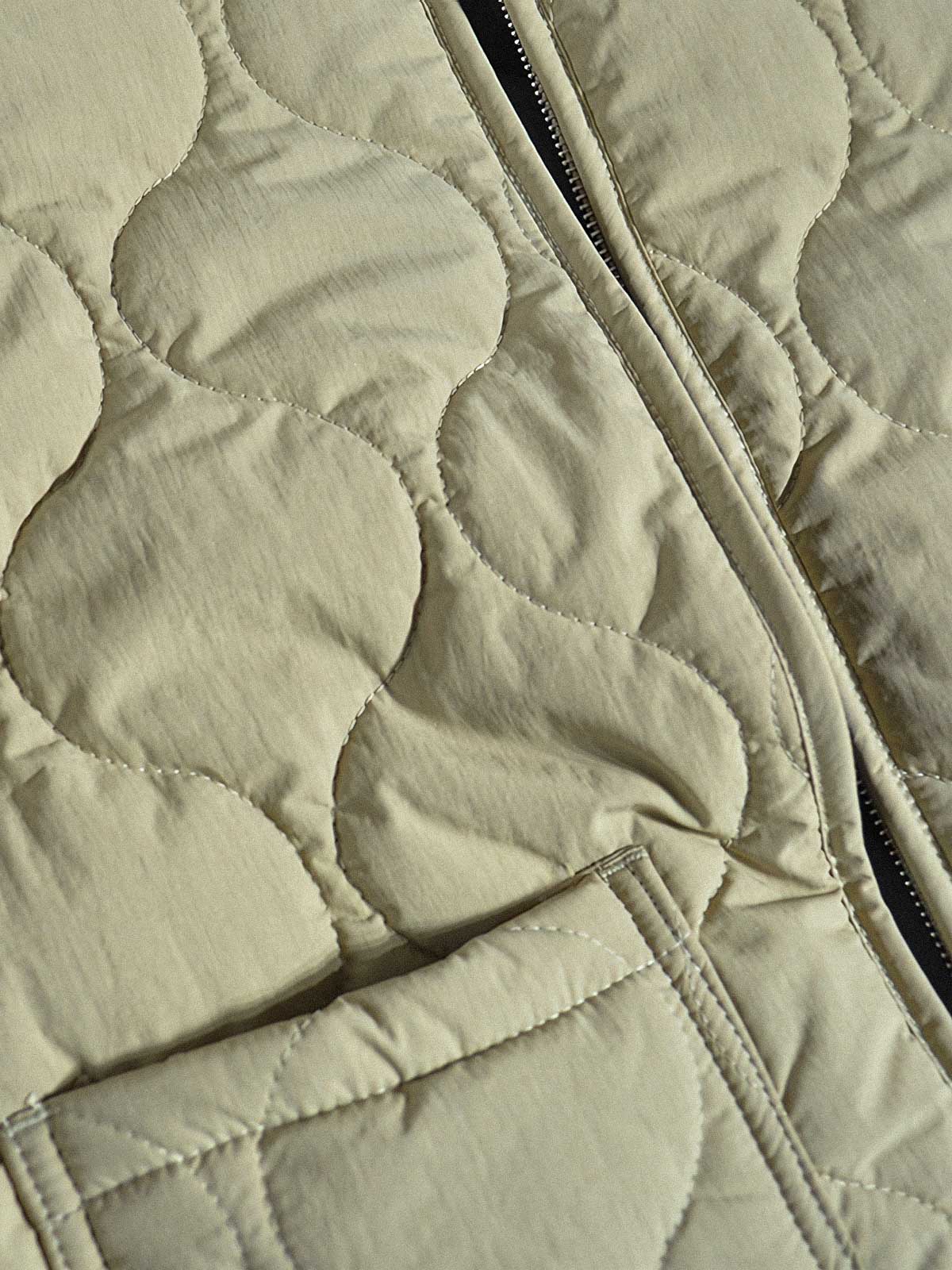 製品画像:
軽量で高密度撥水素材を使用したアウトドアスタイルのキルティングインサレーションベスト、波模様のキルティングデザインと大容量ワークポケット付き
詳細画像:
波模様のキルティングデザイン、細部にこだわった高密度撥水素材、内側の起毛素材とバックル開きディテールのクローズアップ