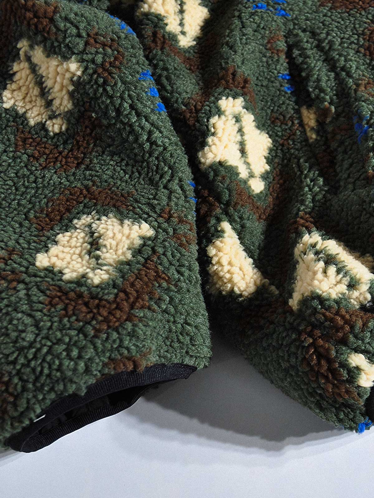 製品画像:
リバーシブルフェイクシアリング中綿ジャケット、アウトドア素材と民族風フェイクシアリングデザインを融合、秋冬の実用的で暖かいアイテム
詳細画像:
民族風フェイクシアリング素材と高密度アウトドア素材のディテールクローズアップ、防風性とデザイン性を兼ね備えたリバーシブルジャケット