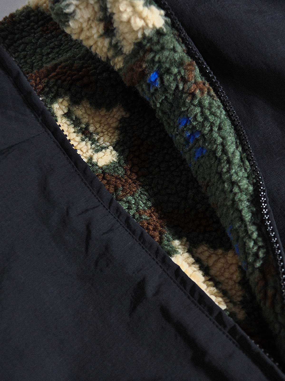 製品画像:
リバーシブルフェイクシアリング中綿ジャケット、アウトドア素材と民族風フェイクシアリングデザインを融合、秋冬の実用的で暖かいアイテム
詳細画像:
民族風フェイクシアリング素材と高密度アウトドア素材のディテールクローズアップ、防風性とデザイン性を兼ね備えたリバーシブルジャケット