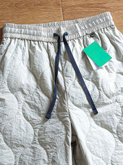 製品画像: 防風・防水機能を備えたキルティング中綿入り保温パンツ全体展示図。冬のアウトドア活動や寒い季節のカジュアルコーディネートに最適な高機能パンツ。
詳細画像: 高反発中綿が使用されたキルティングデザインのディテール。ウエストの伸縮性ゴムとドローコード、裾部分の調節機能で、機能性と快適さを兼ね備えたアウトドアパンツの特徴。