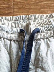 製品画像: 防風・防水機能を備えたキルティング中綿入り保温パンツ全体展示図。冬のアウトドア活動や寒い季節のカジュアルコーディネートに最適な高機能パンツ。
詳細画像: 高反発中綿が使用されたキルティングデザインのディテール。ウエストの伸縮性ゴムとドローコード、裾部分の調節機能で、機能性と快適さを兼ね備えたアウトドアパンツの特徴。