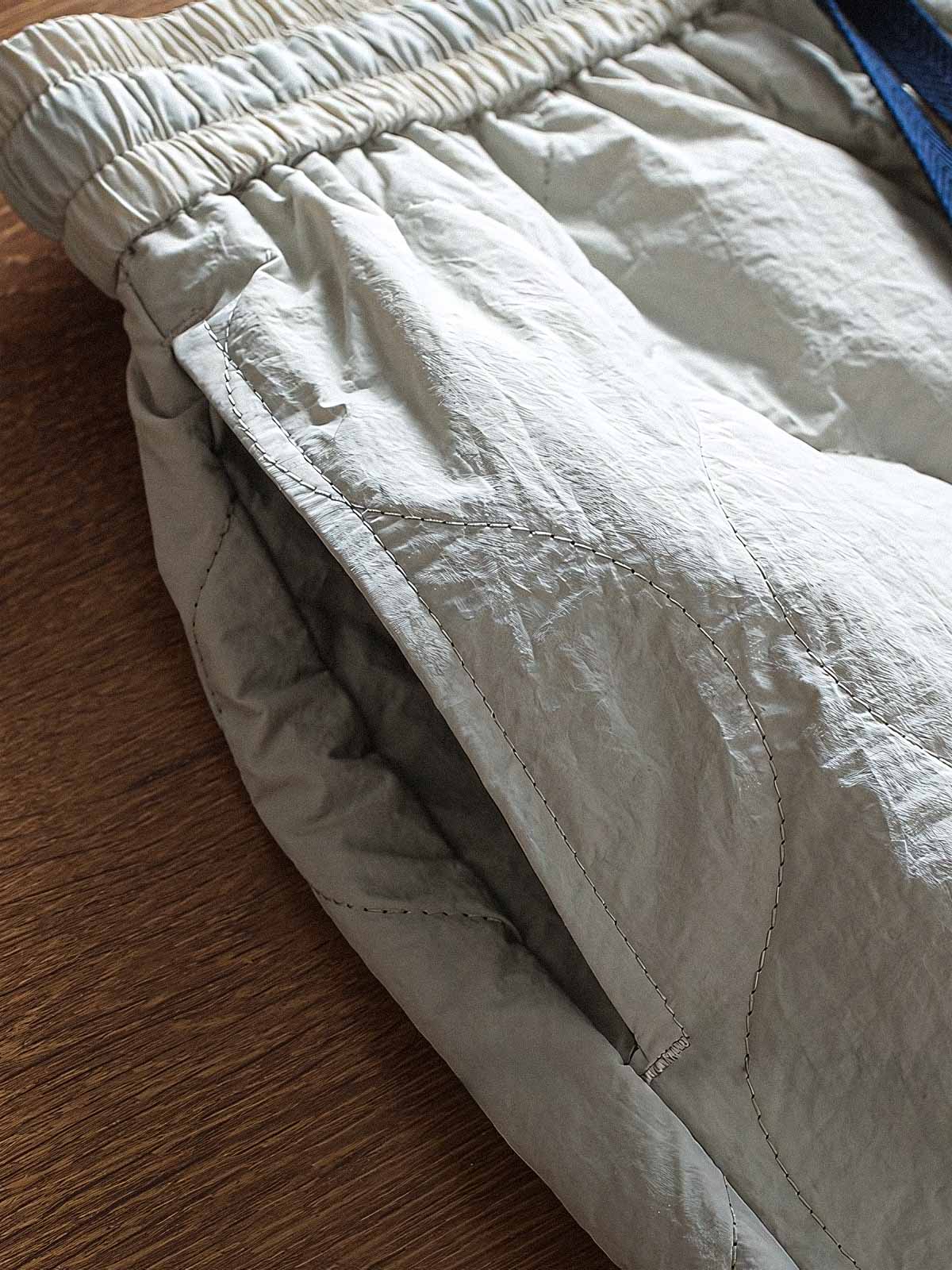 製品画像: 防風・防水機能を備えたキルティング中綿入り保温パンツ全体展示図。冬のアウトドア活動や寒い季節のカジュアルコーディネートに最適な高機能パンツ。
詳細画像: 高反発中綿が使用されたキルティングデザインのディテール。ウエストの伸縮性ゴムとドローコード、裾部分の調節機能で、機能性と快適さを兼ね備えたアウトドアパンツの特徴。