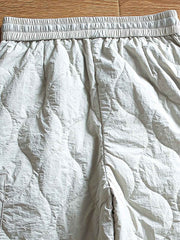 製品画像: 防風・防水機能を備えたキルティング中綿入り保温パンツ全体展示図。冬のアウトドア活動や寒い季節のカジュアルコーディネートに最適な高機能パンツ。
詳細画像: 高反発中綿が使用されたキルティングデザインのディテール。ウエストの伸縮性ゴムとドローコード、裾部分の調節機能で、機能性と快適さを兼ね備えたアウトドアパンツの特徴。