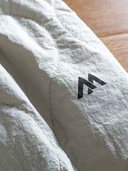 製品画像: 防風・防水機能を備えたキルティング中綿入り保温パンツ全体展示図。冬のアウトドア活動や寒い季節のカジュアルコーディネートに最適な高機能パンツ。
詳細画像: 高反発中綿が使用されたキルティングデザインのディテール。ウエストの伸縮性ゴムとドローコード、裾部分の調節機能で、機能性と快適さを兼ね備えたアウトドアパンツの特徴。