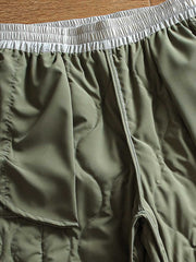 製品画像: 防風・防水機能を備えたキルティング中綿入り保温パンツ全体展示図。冬のアウトドア活動や寒い季節のカジュアルコーディネートに最適な高機能パンツ。
詳細画像: 高反発中綿が使用されたキルティングデザインのディテール。ウエストの伸縮性ゴムとドローコード、裾部分の調節機能で、機能性と快適さを兼ね備えたアウトドアパンツの特徴。