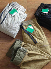 製品画像: 防風・防水機能を備えたキルティング中綿入り保温パンツ全体展示図。冬のアウトドア活動や寒い季節のカジュアルコーディネートに最適な高機能パンツ。
詳細画像: 高反発中綿が使用されたキルティングデザインのディテール。ウエストの伸縮性ゴムとドローコード、裾部分の調節機能で、機能性と快適さを兼ね備えたアウトドアパンツの特徴。