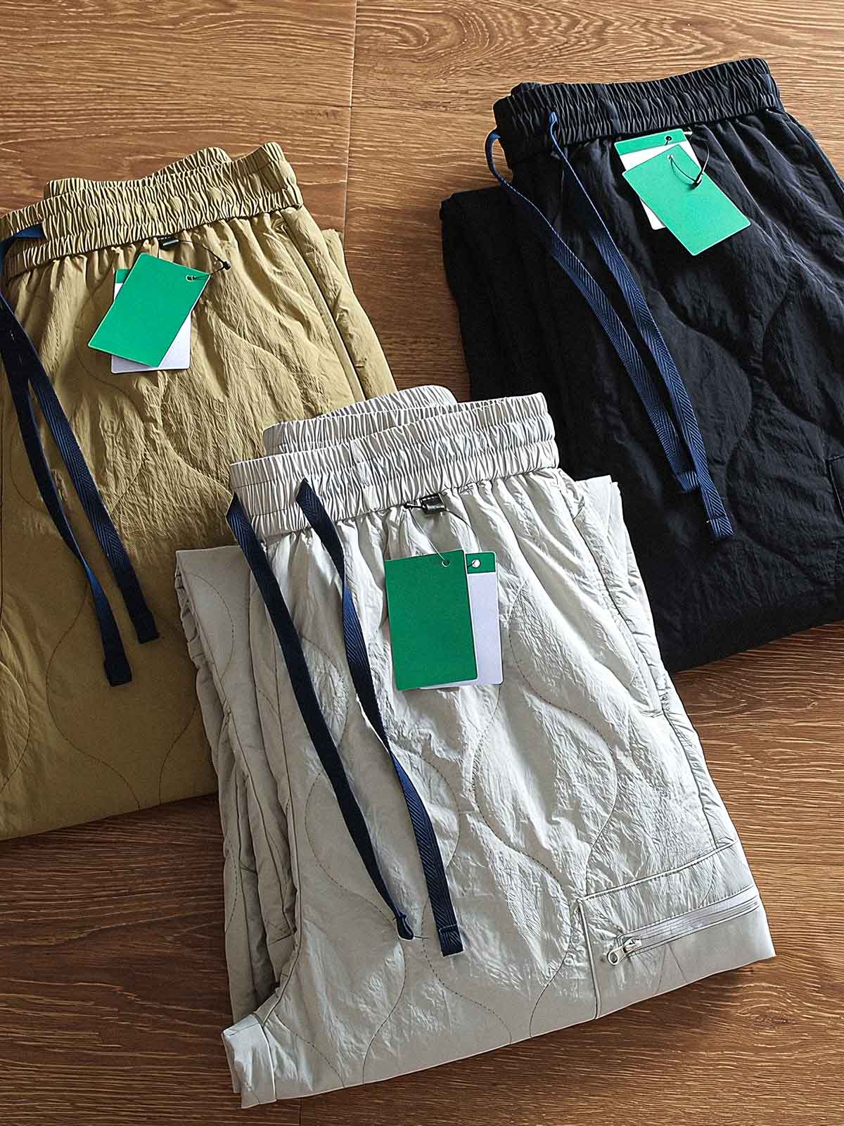 製品画像: 防風・防水機能を備えたキルティング中綿入り保温パンツ全体展示図。冬のアウトドア活動や寒い季節のカジュアルコーディネートに最適な高機能パンツ。
詳細画像: 高反発中綿が使用されたキルティングデザインのディテール。ウエストの伸縮性ゴムとドローコード、裾部分の調節機能で、機能性と快適さを兼ね備えたアウトドアパンツの特徴。