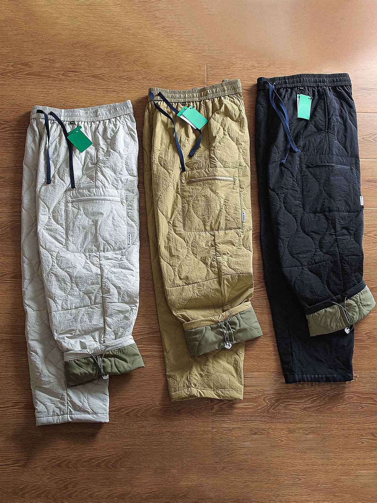 製品画像: 防風・防水機能を備えたキルティング中綿入り保温パンツ全体展示図。冬のアウトドア活動や寒い季節のカジュアルコーディネートに最適な高機能パンツ。
詳細画像: 高反発中綿が使用されたキルティングデザインのディテール。ウエストの伸縮性ゴムとドローコード、裾部分の調節機能で、機能性と快適さを兼ね備えたアウトドアパンツの特徴。