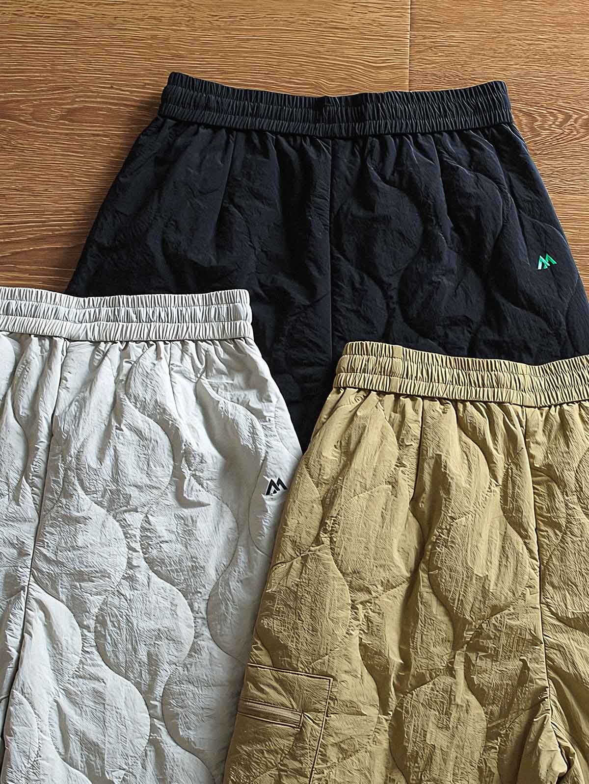 製品画像: 防風・防水機能を備えたキルティング中綿入り保温パンツ全体展示図。冬のアウトドア活動や寒い季節のカジュアルコーディネートに最適な高機能パンツ。
詳細画像: 高反発中綿が使用されたキルティングデザインのディテール。ウエストの伸縮性ゴムとドローコード、裾部分の調節機能で、機能性と快適さを兼ね備えたアウトドアパンツの特徴。