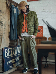 詳細画像: リバーシブルデザイン(オリーブグリーンとレスキューオレンジ)、袖口のリブ編みが冷気をシャットアウト。軽量でありながら優れた保温性を提供。
モデル画像: モデルが弧形キルティングインナーダウンジャケットを着用、ルーズフィットシルエットと防水性に優れた素材で、秋冬のレイヤードスタイルを演出。