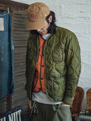 詳細画像: リバーシブルデザイン(オリーブグリーンとレスキューオレンジ)、袖口のリブ編みが冷気をシャットアウト。軽量でありながら優れた保温性を提供。
モデル画像: モデルが弧形キルティングインナーダウンジャケットを着用、ルーズフィットシルエットと防水性に優れた素材で、秋冬のレイヤードスタイルを演出。