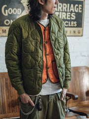 詳細画像: リバーシブルデザイン(オリーブグリーンとレスキューオレンジ)、袖口のリブ編みが冷気をシャットアウト。軽量でありながら優れた保温性を提供。
モデル画像: モデルが弧形キルティングインナーダウンジャケットを着用、ルーズフィットシルエットと防水性に優れた素材で、秋冬のレイヤードスタイルを演出。