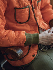 詳細画像: リバーシブルデザイン(オリーブグリーンとレスキューオレンジ)、袖口のリブ編みが冷気をシャットアウト。軽量でありながら優れた保温性を提供。
モデル画像: モデルが弧形キルティングインナーダウンジャケットを着用、ルーズフィットシルエットと防水性に優れた素材で、秋冬のレイヤードスタイルを演出。