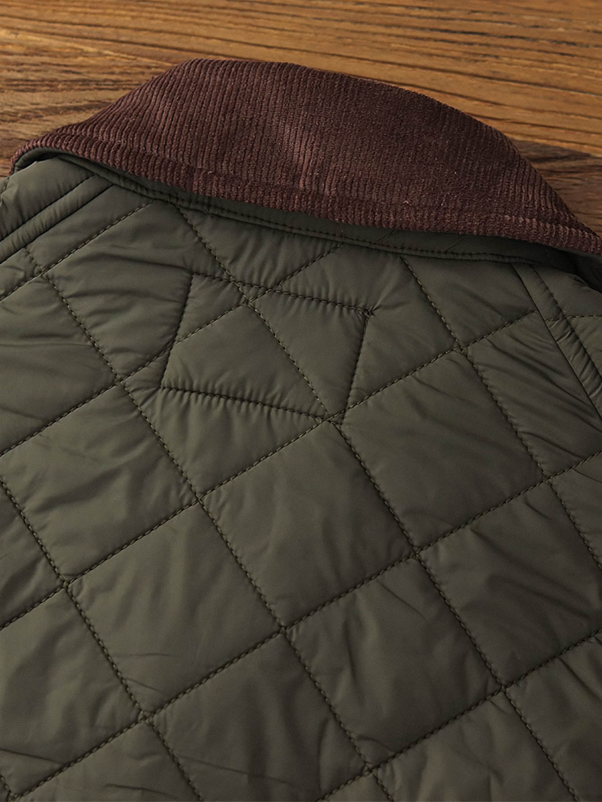 製品画像: ヴィンテージダイヤキルト中綿ジャケット正面展示図。クラシックなダイヤキルト縫製とコーデュロイ襟が特徴的なデザイン。軽量で暖かく、スリムなシルエット。
詳細画像: TALONの真鍮ジッパー、ラグランスリーブのディテール。大きなサイドポケットと斜めの隠しポケットが実用的なデザイン。