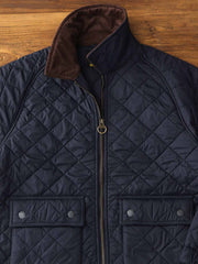 製品画像: ヴィンテージダイヤキルト中綿ジャケット正面展示図。クラシックなダイヤキルト縫製とコーデュロイ襟が特徴的なデザイン。軽量で暖かく、スリムなシルエット。
詳細画像: TALONの真鍮ジッパー、ラグランスリーブのディテール。大きなサイドポケットと斜めの隠しポケットが実用的なデザイン。