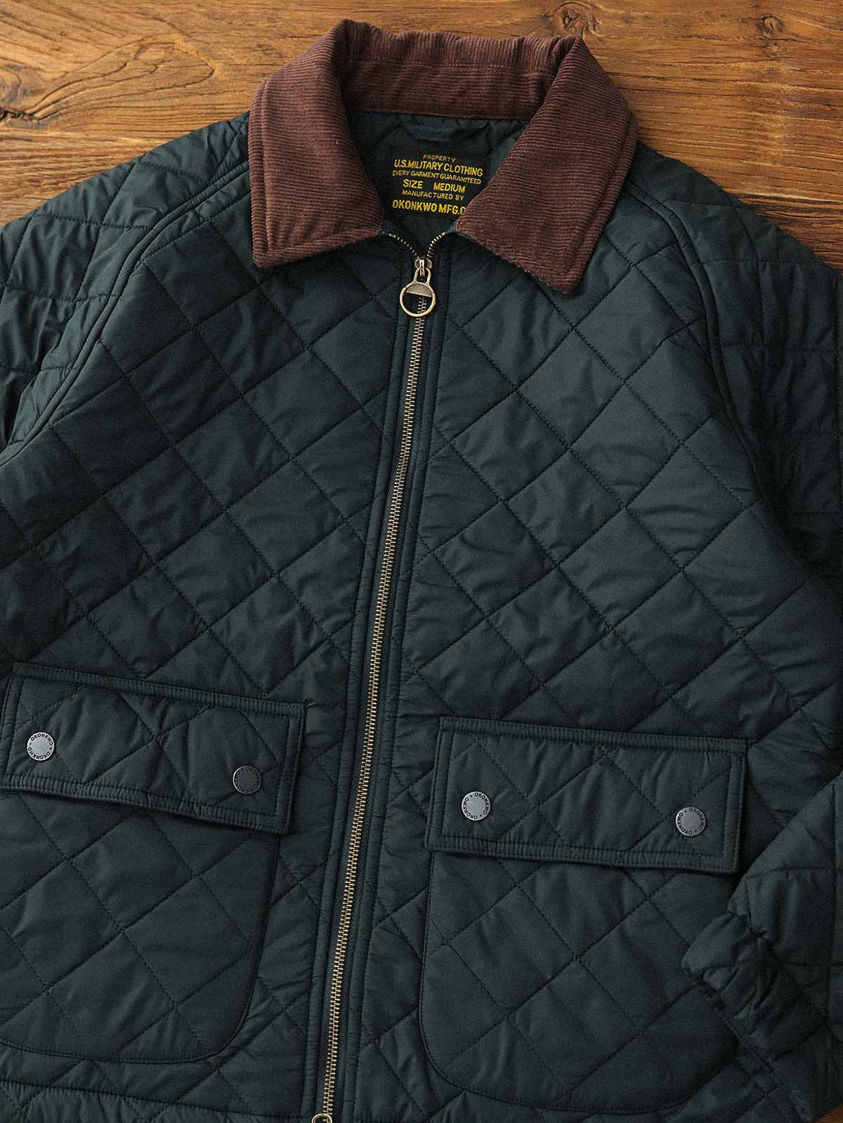 製品画像: ヴィンテージダイヤキルト中綿ジャケット正面展示図。クラシックなダイヤキルト縫製とコーデュロイ襟が特徴的なデザイン。軽量で暖かく、スリムなシルエット。
詳細画像: TALONの真鍮ジッパー、ラグランスリーブのディテール。大きなサイドポケットと斜めの隠しポケットが実用的なデザイン。