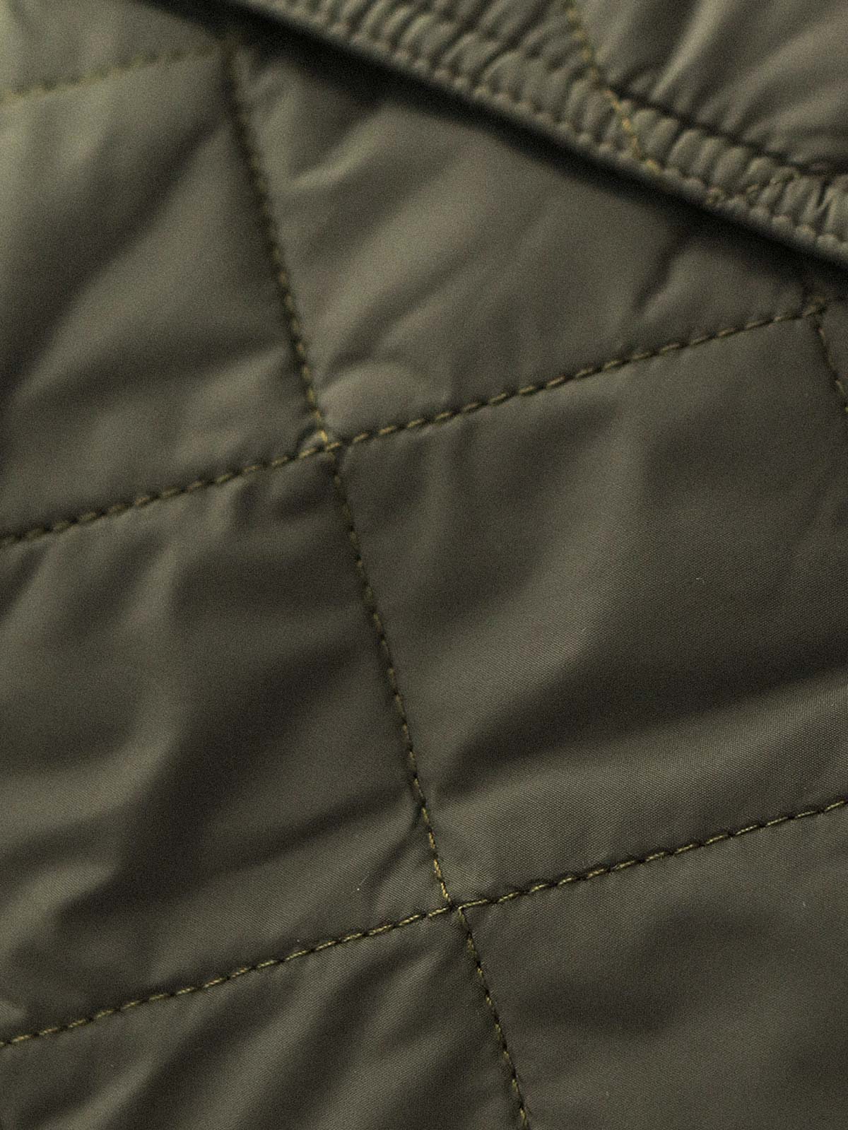 製品画像: ヴィンテージダイヤキルト中綿ジャケット正面展示図。クラシックなダイヤキルト縫製とコーデュロイ襟が特徴的なデザイン。軽量で暖かく、スリムなシルエット。
詳細画像: TALONの真鍮ジッパー、ラグランスリーブのディテール。大きなサイドポケットと斜めの隠しポケットが実用的なデザイン。