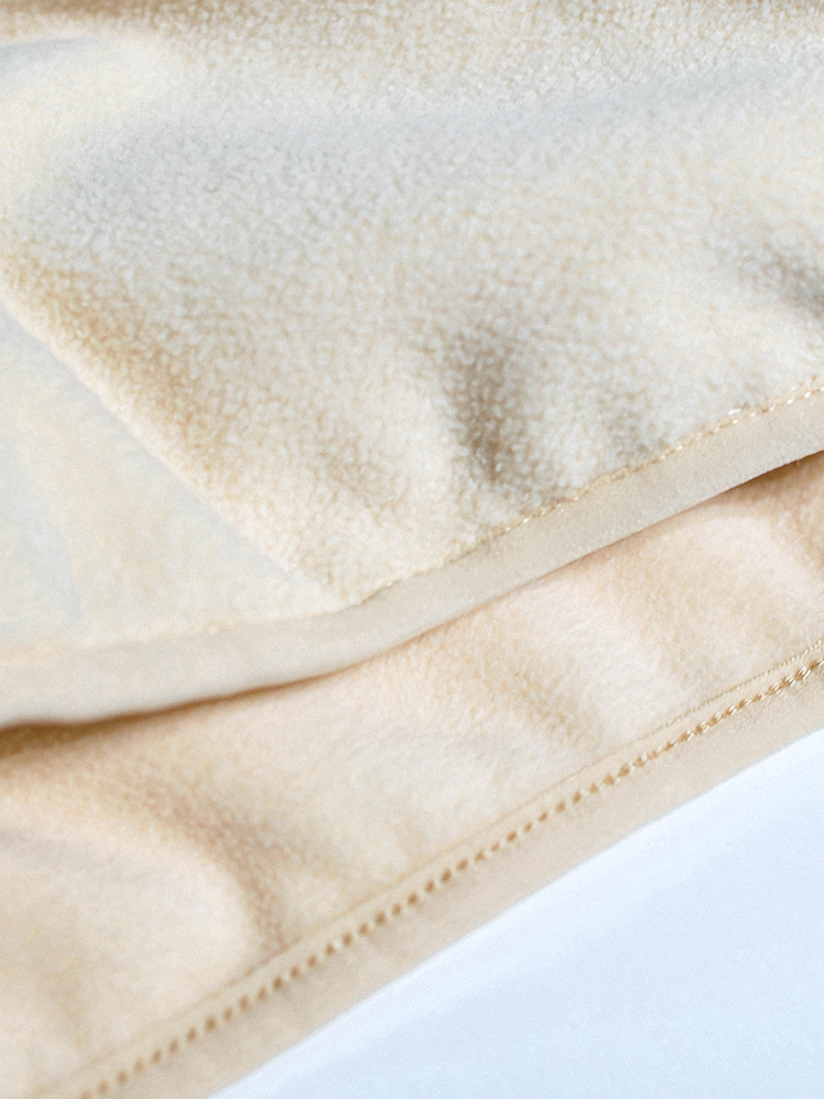 製品画像: サイドジップフリーススウェットの正面展示画像。ヴィンテージ風デザインが特徴で、ボタン付きネックデザインがクルーネックとノーカラーの2通りのスタイルを楽しめます。両面起毛の75Dフリース素材で、優れた保温性と通気性を実現し、アウトドアや日常使いに最適。
詳細画像: サイドジップのスリットデザイン、ラグランスリーブ、オーバーサイズのカットが特徴。伸縮性のあるリブ袖と裾で、動きやすさと快適さを提供。耐久性に優れ、毛玉ができにくいフリース素材を使用。