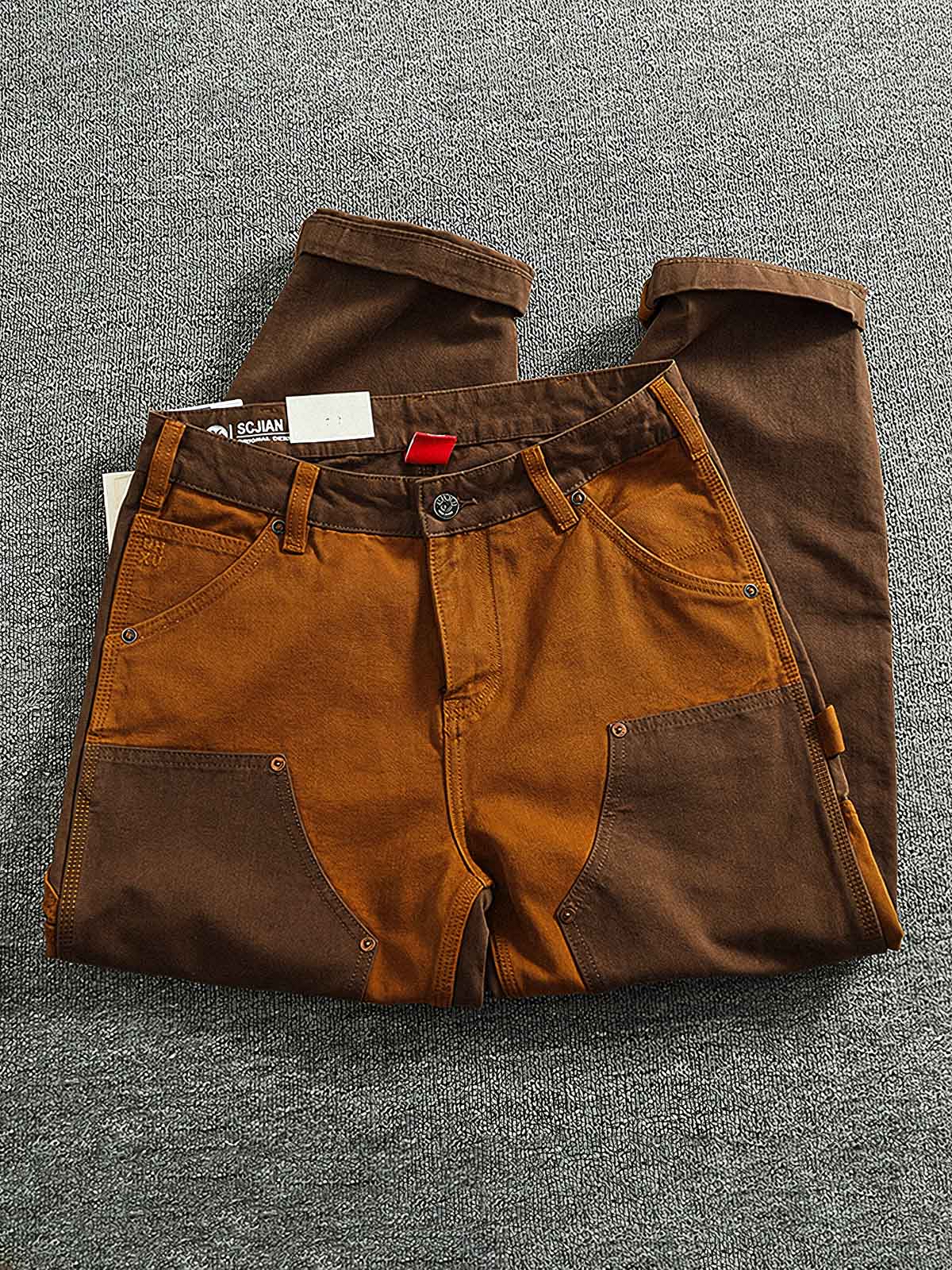 製品画像:粗い織りキャンバス素材のコントラストカラーのパッチワークカーゴパンツ、レトロなデザインでストリートファッションやバイクスタイルにぴったり。金属製ボタンとYKKジッパーが精緻な仕上がり。
詳細画像:粗い織りのキャンバス素材、コントラストカラーのパッチワークデザイン、金属製ボタンやYKKジッパーのディテール、テーパードデザインでファッション性がアップ。