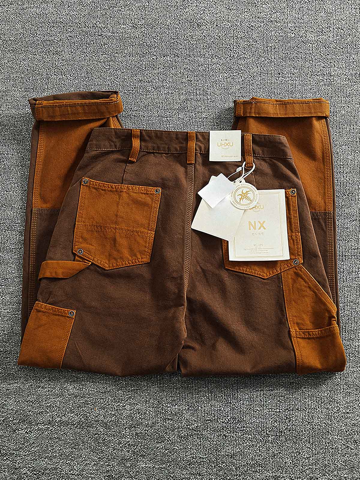 製品画像:粗い織りキャンバス素材のコントラストカラーのパッチワークカーゴパンツ、レトロなデザインでストリートファッションやバイクスタイルにぴったり。金属製ボタンとYKKジッパーが精緻な仕上がり。
詳細画像:粗い織りのキャンバス素材、コントラストカラーのパッチワークデザイン、金属製ボタンやYKKジッパーのディテール、テーパードデザインでファッション性がアップ。