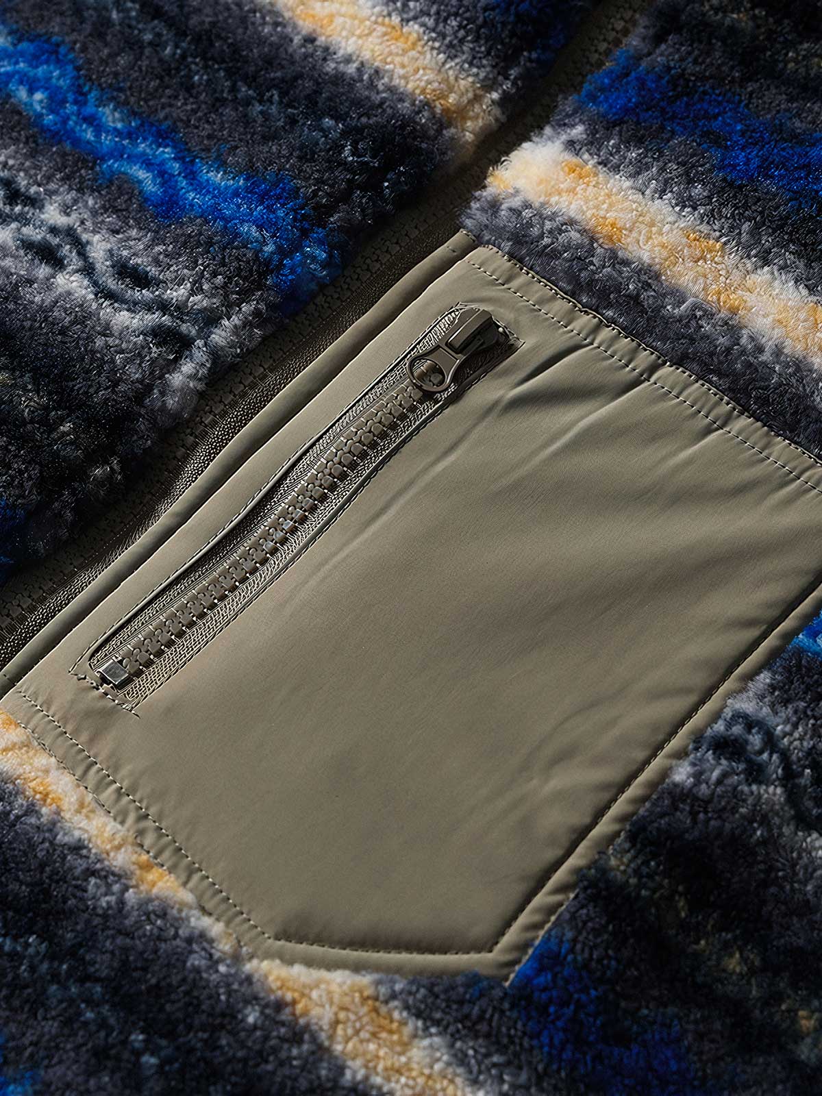 製品画像: リバーシブルデザインのラムファーワークベスト正面展示画像、民族風スタイルで暖かさと快適さを提供するユニセックスアイテム。
詳細画像: ベストの内側に施されたラムファーのディテールアップ、リバーシブルデザインによるコーディネートの幅が広がる特徴。