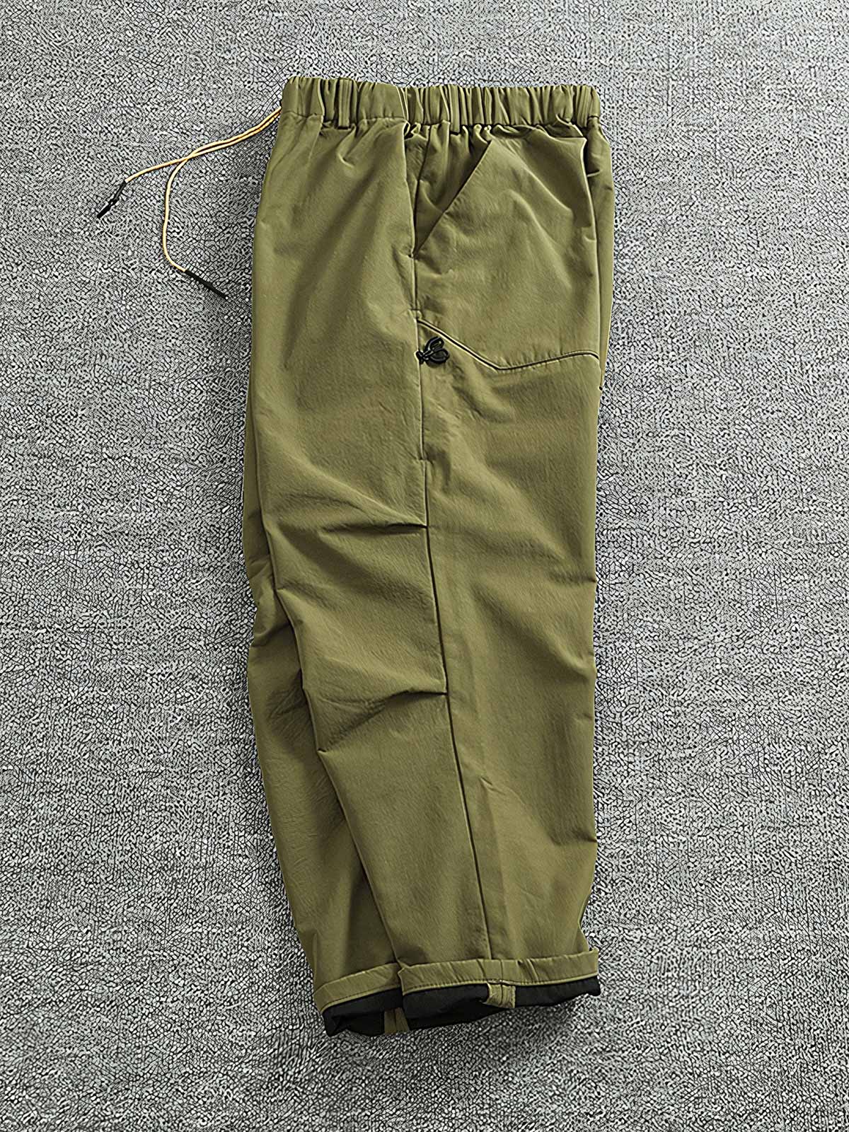 製品画像: 複合素材の加厚デザインが特徴の機能性ワークパンツ正面展示画像、アウトドアと日常使いに最適なアイテム。
詳細画像: ワークパンツのディテールアップ、スポーツジップポケットと膝部の3D立体カットによる最適なフィット感。