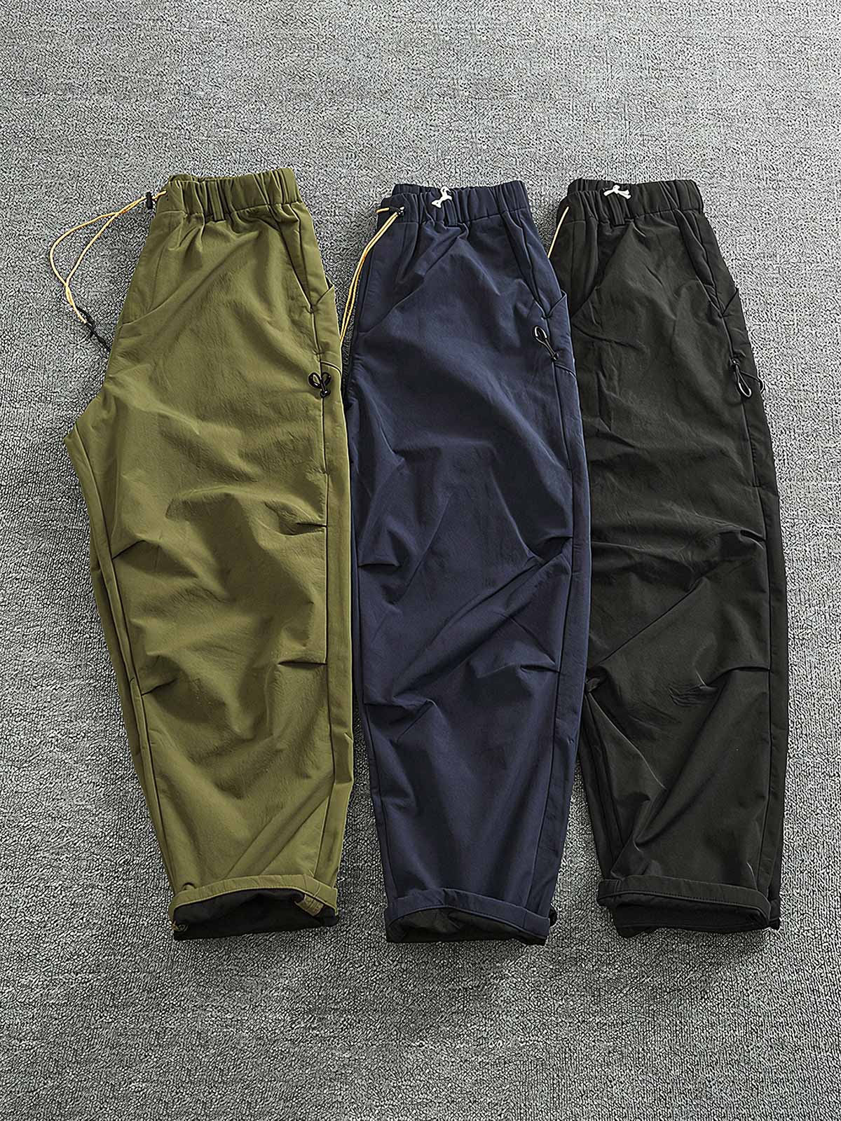 製品画像: 複合素材の加厚デザインが特徴の機能性ワークパンツ正面展示画像、アウトドアと日常使いに最適なアイテム。
詳細画像: ワークパンツのディテールアップ、スポーツジップポケットと膝部の3D立体カットによる最適なフィット感。