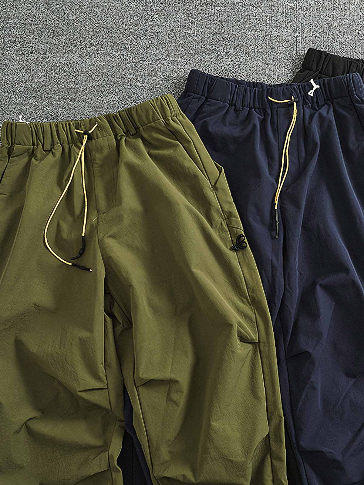 製品画像: 複合素材の加厚デザインが特徴の機能性ワークパンツ正面展示画像、アウトドアと日常使いに最適なアイテム。
詳細画像: ワークパンツのディテールアップ、スポーツジップポケットと膝部の3D立体カットによる最適なフィット感。