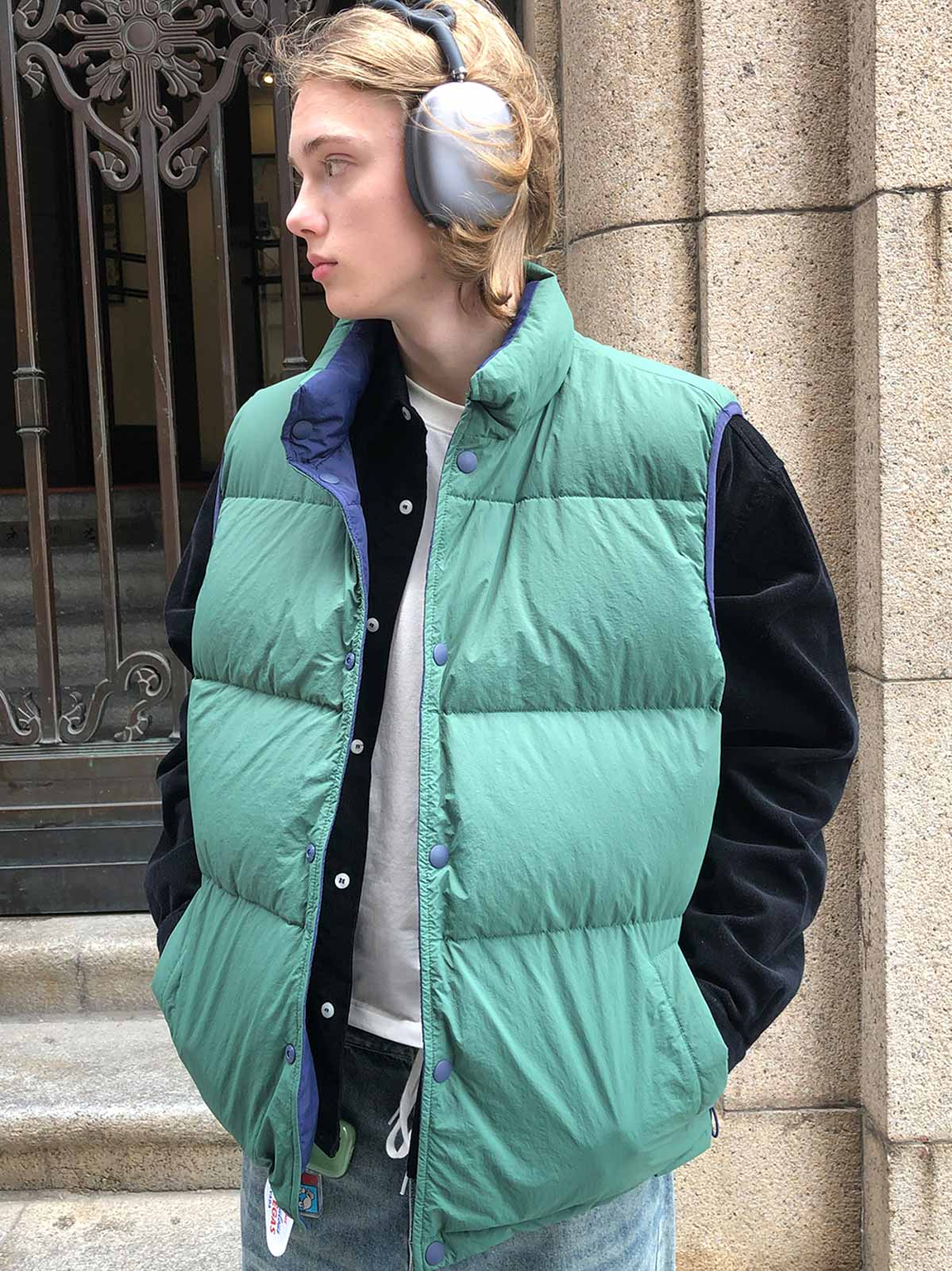 詳細画像:
リバーシブルダウンベストの詳細画像。ホワイトダックダウンを使用した充填材が内蔵されており、調節可能なドローコードでシルエットを自由に変えることができます。耐久性に優れたポリアミド繊維を採用しており、長時間使用しても快適さを保ちます。
モデル画像:
モデルがリバーシブルダウンベストを着用した画像。アメリカン・ヴィンテージスタイルを反映したデザインが特徴で、冬のカジュアルなアクティビティにぴったりなアイテムです。どんなコーディネートにも合わせやすく、寒い季節の外出時に最適です。