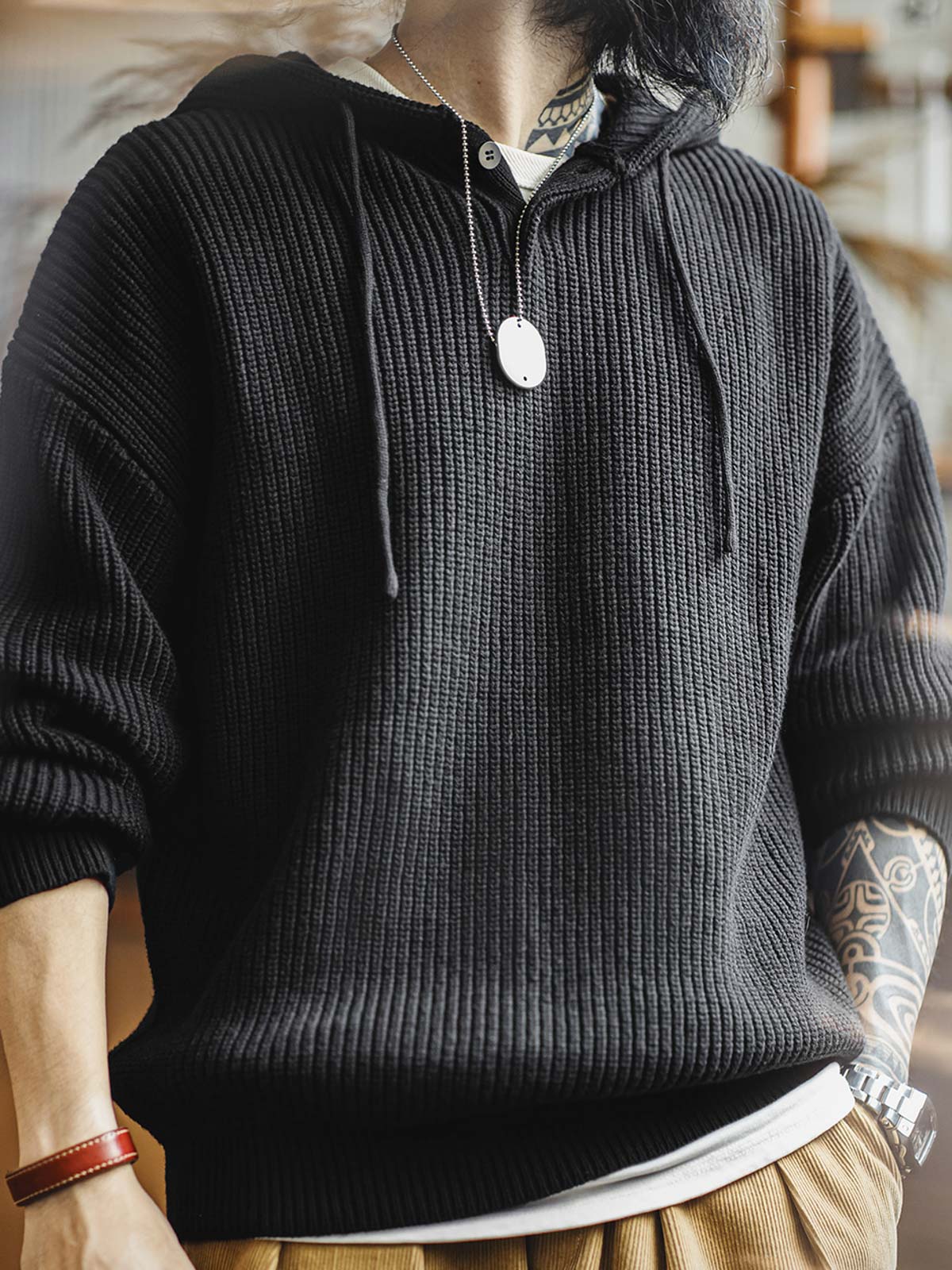 詳細画像:
縦じまのニット素材、ヘンリーネックのY字デザイン、フードとドローコード付き、リブディテールでフィット感強調、胸元のカスタムヴィンテージラベル
モデル画像:
モデルがヘンリーネック縦じまニットパーカーを着用、リラックスしたカジュアルスタイルでワイドパンツやデニムと完璧にコーディネート