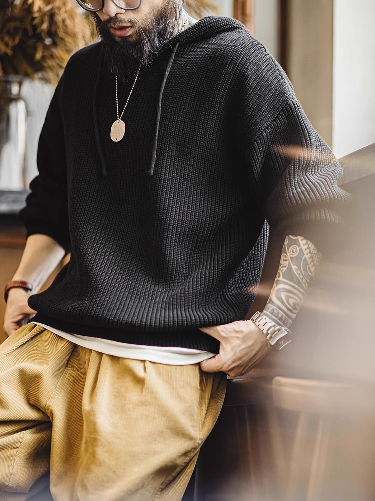 詳細画像:
縦じまのニット素材、ヘンリーネックのY字デザイン、フードとドローコード付き、リブディテールでフィット感強調、胸元のカスタムヴィンテージラベル
モデル画像:
モデルがヘンリーネック縦じまニットパーカーを着用、リラックスしたカジュアルスタイルでワイドパンツやデニムと完璧にコーディネート