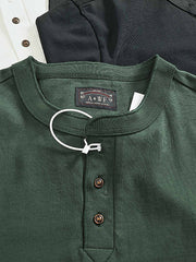 製品画像
「ヘンリーネック 長袖Tシャツ。高密度コットン素材とアメカジ風ウォッシュ加工が特徴で、ヴィンテージ感と耐久性を兼ね備えたシンプルなデザイン」
詳細画像
「ヘンリーネックの金属ボタンとアメカジ風ウォッシュ加工による自然なレトロ感。高密度コットンの厚手生地で、クラシックなディテールが際立つ一枚」