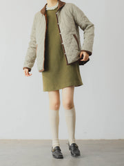 詳細画像: ツートーンのダイヤ柄キルティング加工が施されたコート、ポリエステル素材で軽量かつ耐久性のあるデザイン、ディテールにこだわったアクセント。
モデル画像: スカートやパンツとのコーディネートでイギリス風スクールスタイルを演出したモデルが着用したピーターパンカラーコート。