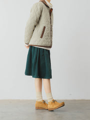 詳細画像: ツートーンのダイヤ柄キルティング加工が施されたコート、ポリエステル素材で軽量かつ耐久性のあるデザイン、ディテールにこだわったアクセント。
モデル画像: スカートやパンツとのコーディネートでイギリス風スクールスタイルを演出したモデルが着用したピーターパンカラーコート。