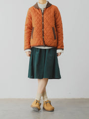 詳細画像: ツートーンのダイヤ柄キルティング加工が施されたコート、ポリエステル素材で軽量かつ耐久性のあるデザイン、ディテールにこだわったアクセント。
モデル画像: スカートやパンツとのコーディネートでイギリス風スクールスタイルを演出したモデルが着用したピーターパンカラーコート。