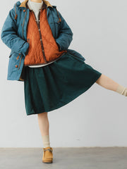 詳細画像: ツートーンのダイヤ柄キルティング加工が施されたコート、ポリエステル素材で軽量かつ耐久性のあるデザイン、ディテールにこだわったアクセント。
モデル画像: スカートやパンツとのコーディネートでイギリス風スクールスタイルを演出したモデルが着用したピーターパンカラーコート。