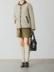 詳細画像: ツートーンのダイヤ柄キルティング加工が施されたコート、ポリエステル素材で軽量かつ耐久性のあるデザイン、ディテールにこだわったアクセント。
モデル画像: スカートやパンツとのコーディネートでイギリス風スクールスタイルを演出したモデルが着用したピーターパンカラーコート。