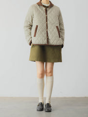 詳細画像: ツートーンのダイヤ柄キルティング加工が施されたコート、ポリエステル素材で軽量かつ耐久性のあるデザイン、ディテールにこだわったアクセント。
モデル画像: スカートやパンツとのコーディネートでイギリス風スクールスタイルを演出したモデルが着用したピーターパンカラーコート。