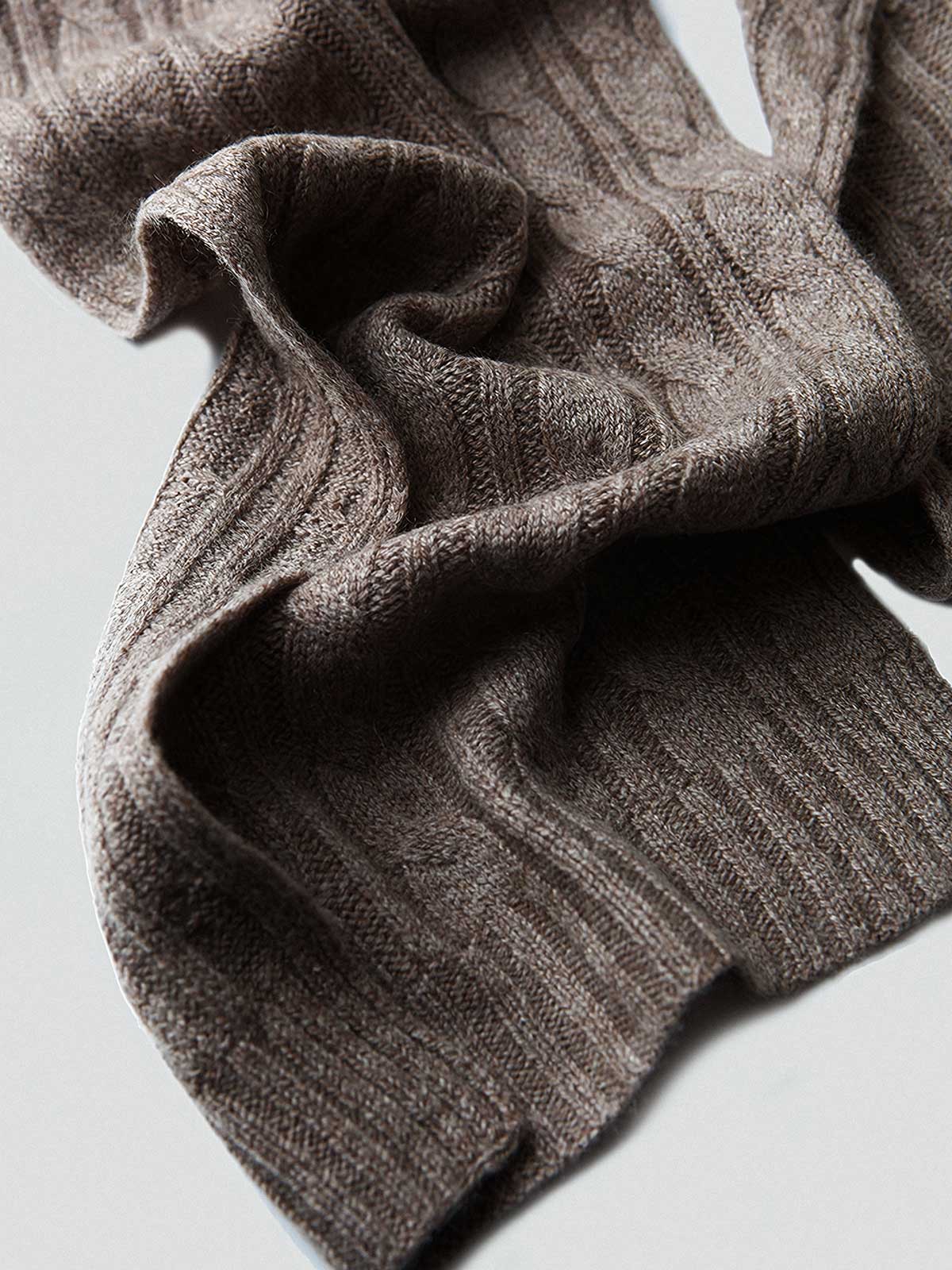 製品画像: ケーブル柄 ウールニット3点セット(マフラー、帽子、手袋)の全体展示画像。エレガントで統一感のあるデザインが特徴。柔らかなラムウールとカシミヤ混紡素材を使用し、冬の防寒用に最適。
詳細画像: ケーブル柄の編み目をクローズアップした詳細画像。高品質ラムウール90%とカシミヤ10%混紡素材の柔らかさと光沢感を強調したディテール。