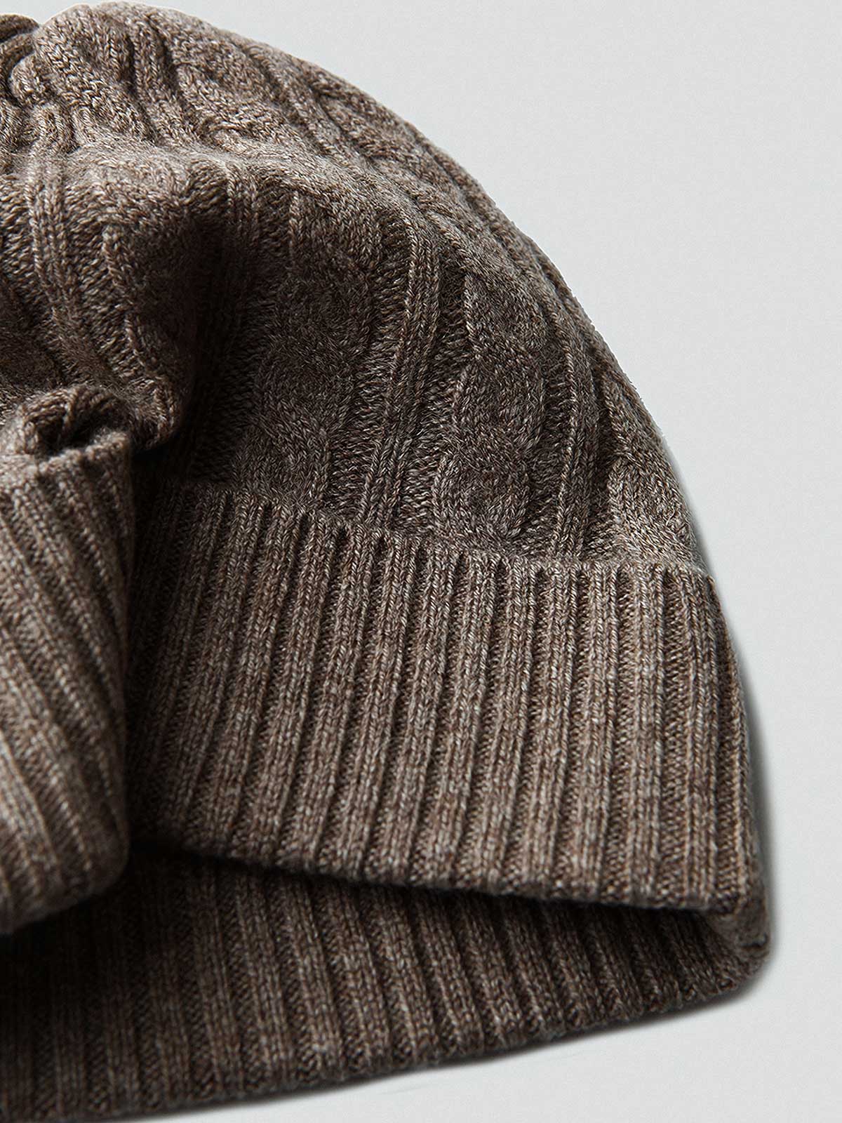 製品画像: ケーブル柄 ウールニット3点セット(マフラー、帽子、手袋)の全体展示画像。エレガントで統一感のあるデザインが特徴。柔らかなラムウールとカシミヤ混紡素材を使用し、冬の防寒用に最適。
詳細画像: ケーブル柄の編み目をクローズアップした詳細画像。高品質ラムウール90%とカシミヤ10%混紡素材の柔らかさと光沢感を強調したディテール。