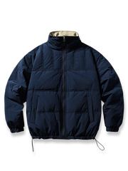 製品画像: リバーシブル ホワイトダックダウンジャケットの全体展示画像。カーキの肌理感ある生地とネイビーのストライプデザインのリバーシブル仕様が特徴。秋冬シーズンに最適な暖かく軽量な一着。
詳細画像: カーキ面の肌理感生地とネイビーストライプ面のディテールをクローズアップした画像。ドローコード付き裾や両サイドポケットの機能性を強調。